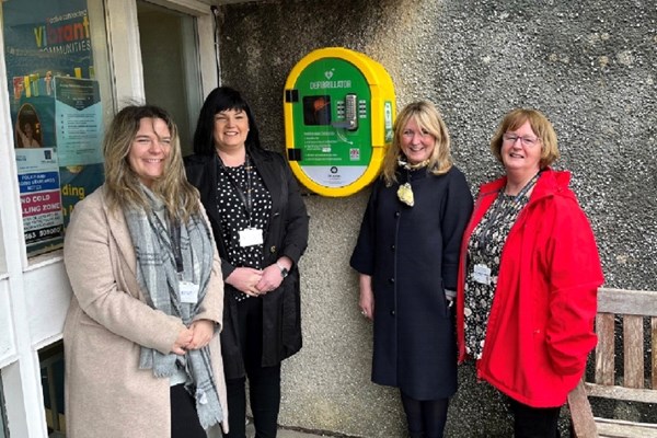 St John Scotland volunteer Jess Duncan (second from right) presents a Public Access Defibrillator in East Ayrshire, March 2022